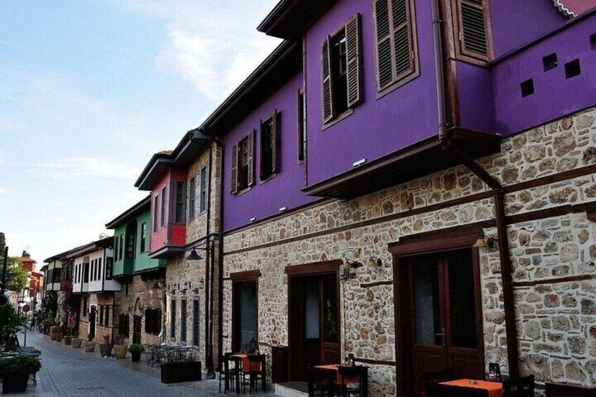A row of colorful buildings with stone facades and wooden shutters. 3