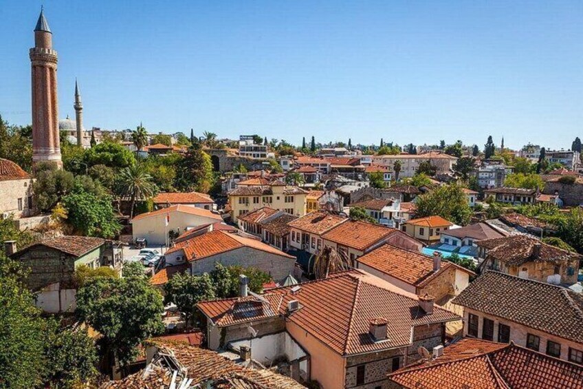 A densely packed urban area with historic buildings, a prominent minaret, and a clear blue sky. 5
