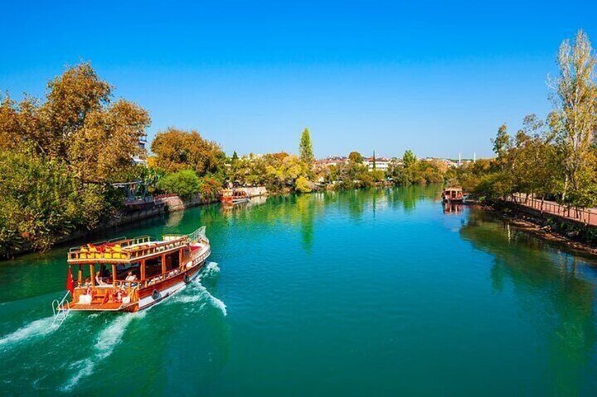 A river with boats, trees, and a clear blue sky. 4