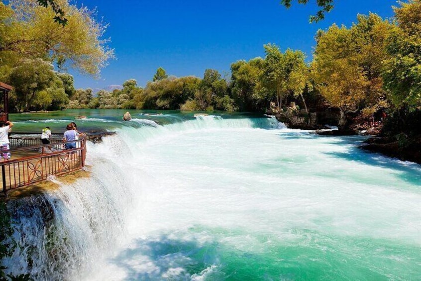 A waterfall, a viewing platform, and surrounding greenery. 1