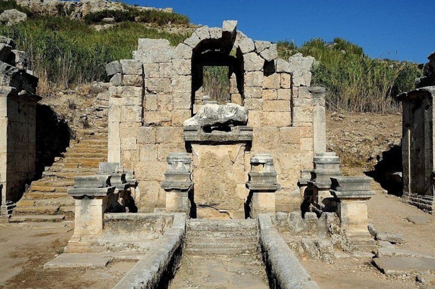 Ancient ruins with stone steps leading up to a central archway. 5