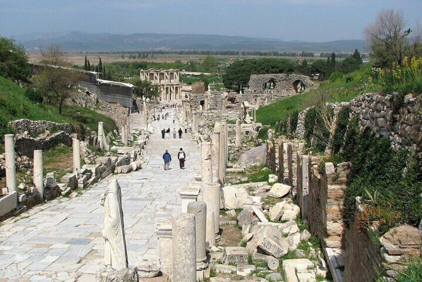 Ancient ruins with stone columns and steps leading towards a distant structure. 5