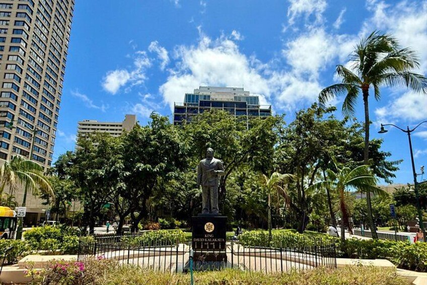 A statue in a park with buildings in the background. 4