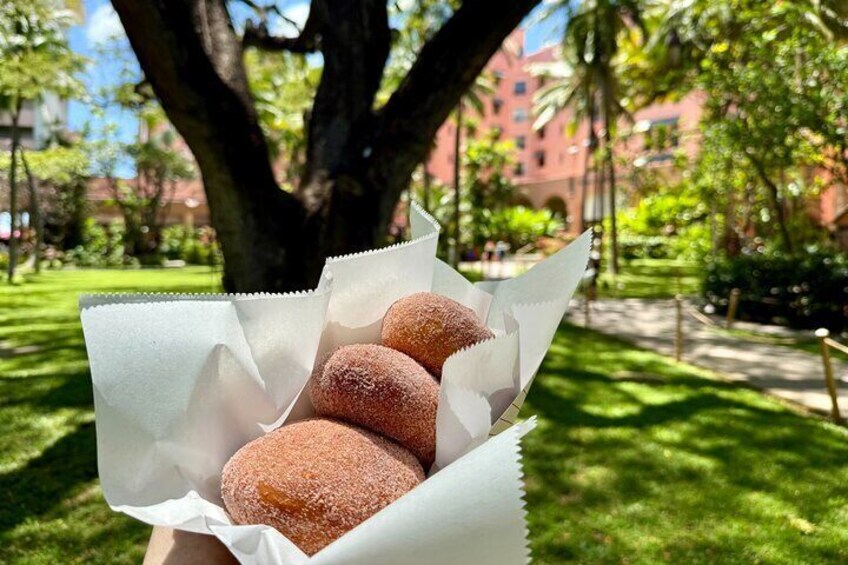 A person holding a paper with three doughnuts. 1