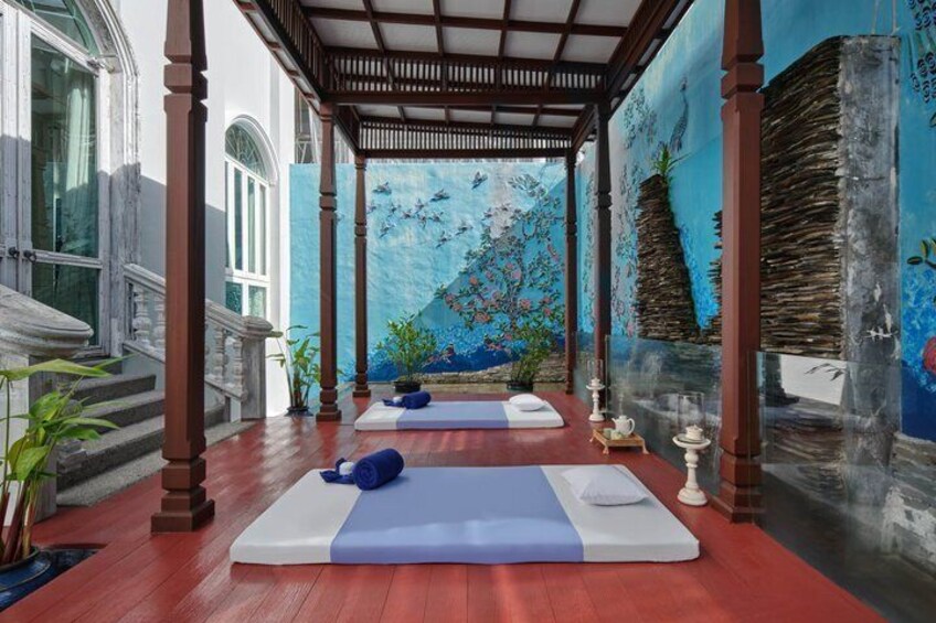 A serene yoga studio with wooden beams, a mural, and mats. 5