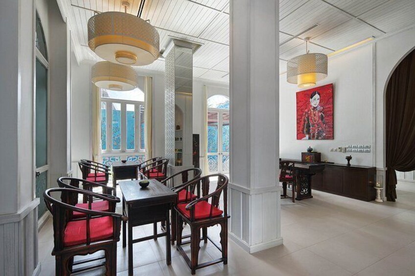 A dining area with wooden chairs and tables, a chandelier, and a large window. 1