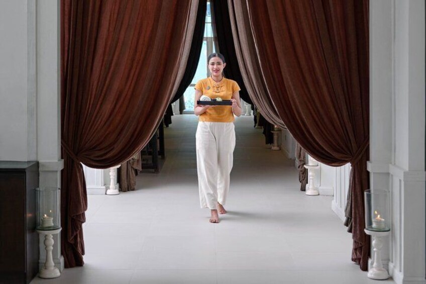 A person walking down a corridor with brown curtains on either side. 4