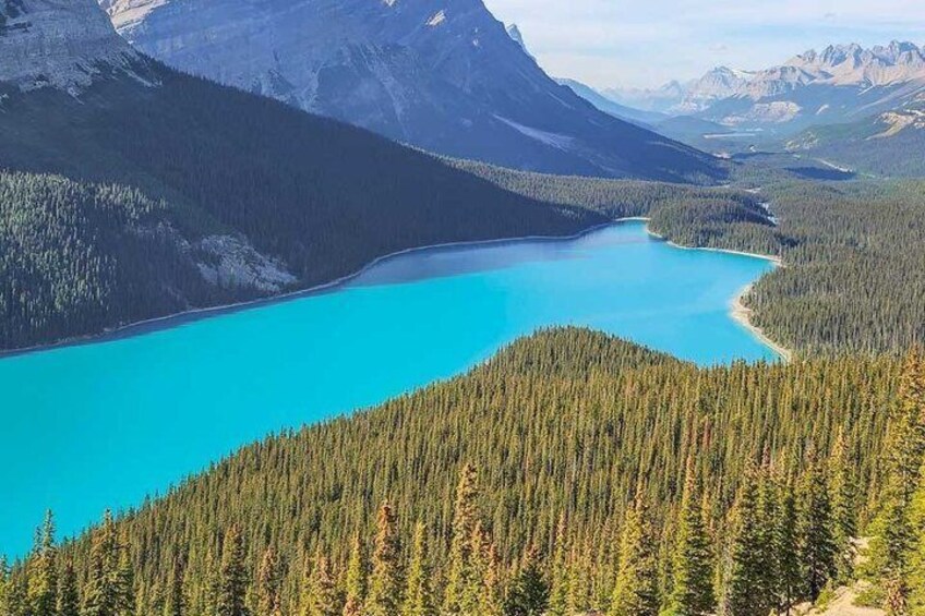 A turquoise lake surrounded by dense forest and mountains. 2