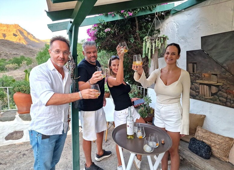 A group of people toasting with drinks, a table with glasses and a bottle, and a mural of animals on a wall. 1