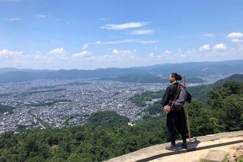 A person standing on a high vantage point overlooking a cityscape. 1
