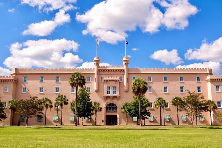 A large, pink building with a central tower, surrounded by palm trees and a clear blue sky. 4