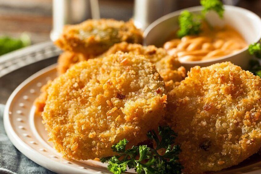 Breaded and fried food items on a plate with a dipping sauce. 4