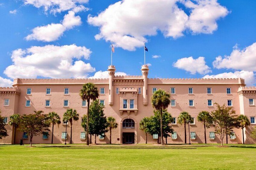 A large, pink building with a central tower, surrounded by palm trees and a clear blue sky. 5