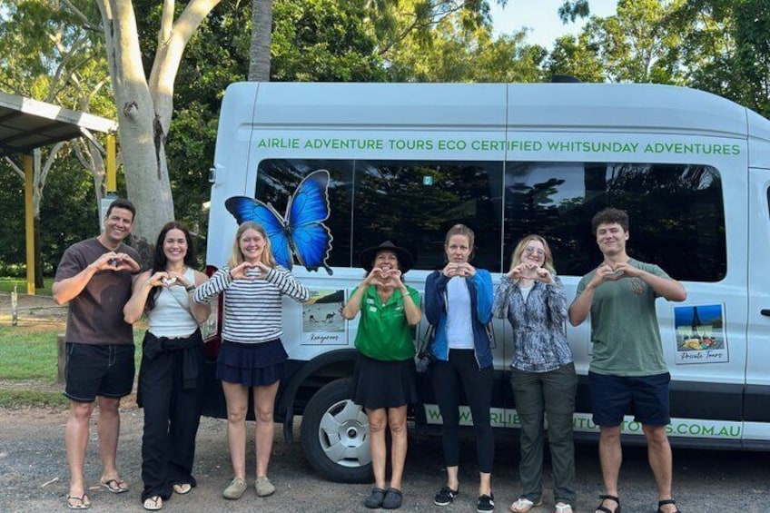 A group of people in front of a van with 'AIRLIE ADVENTURE TOURS ECO CERTIFIED WHITSUNDAY ADVENTURES' written on it. 2
