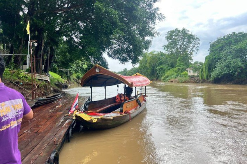 A river with a boat docked at a wooden pier, surrounded by lush greenery. 5