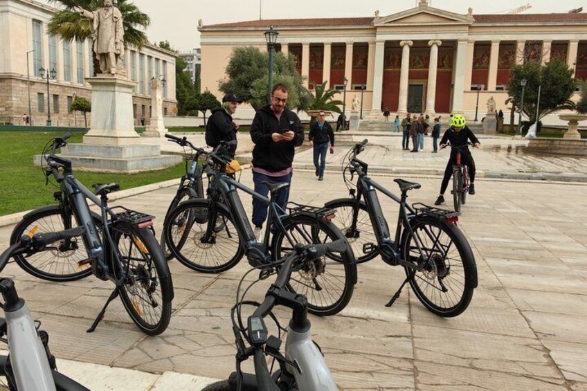 A public square with bicycles, a statue, and a classical building. 5