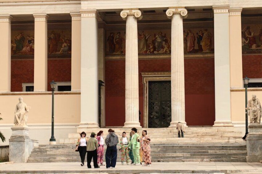 A classical building with columns and a statue in front. 4