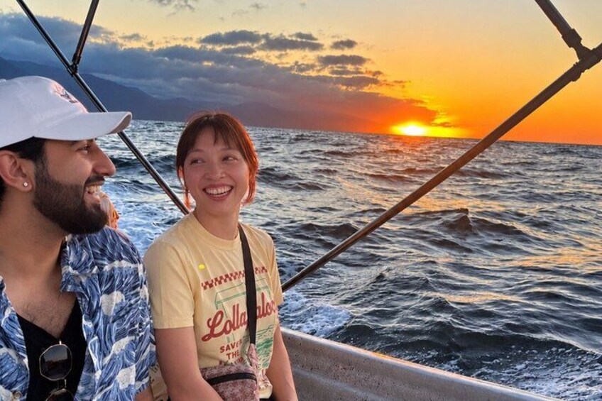 Un bote con dos personas, un atardecer y el océano. 2