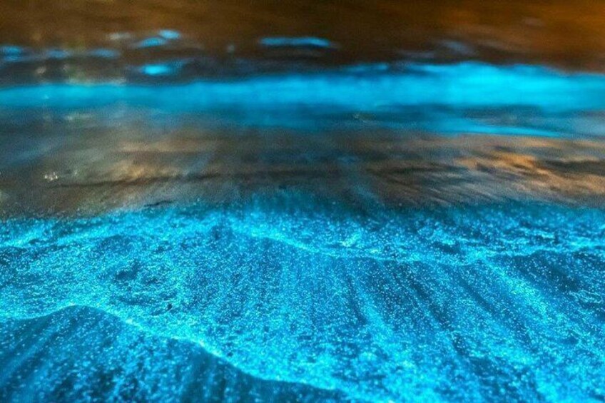 A close-up of a sandy beach with a blue glow beneath the surface. 2
