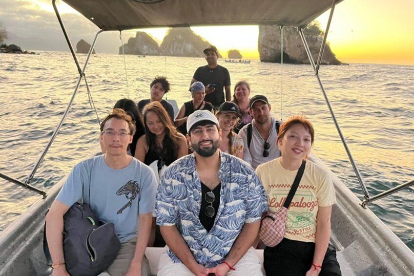 Un grupo de personas en un bote con una costa rocosa al fondo. 4