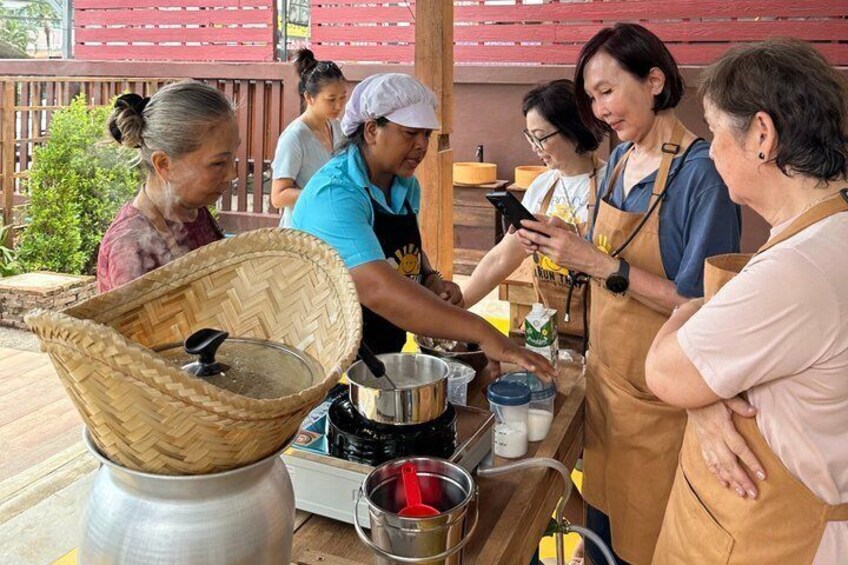 A group of people preparing food outdoors with cooking equipment and a woven basket. 5