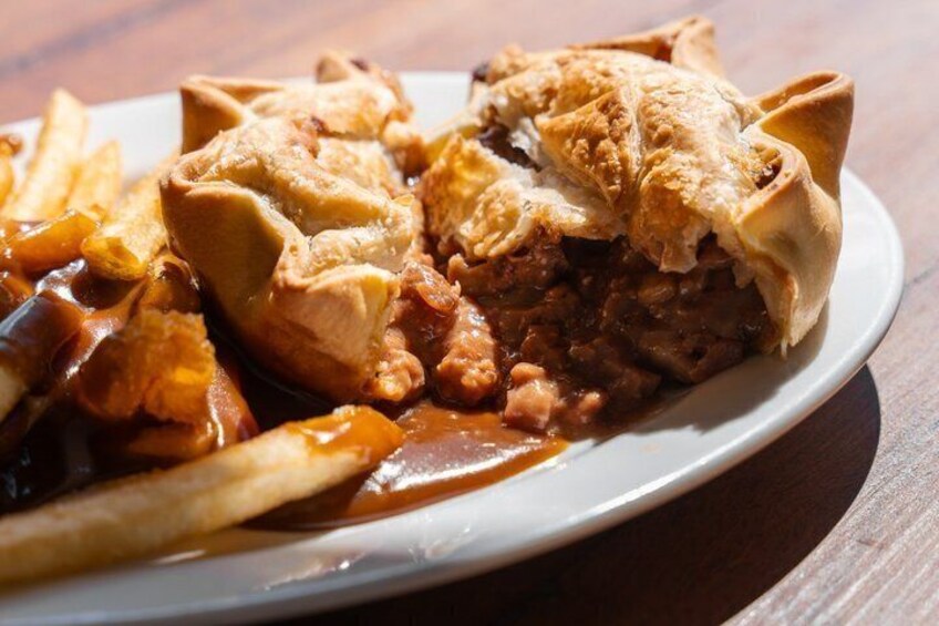 A meat pie with a crust, served with fries and gravy. 4