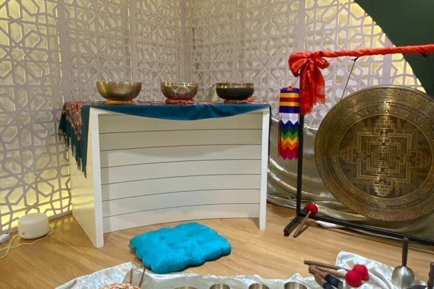 A room with a white cabinet, a blue cushion, and various bowls and a large decorative plate. 5