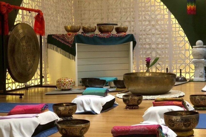 A meditation room with a large gong, bowls, and mats. 4