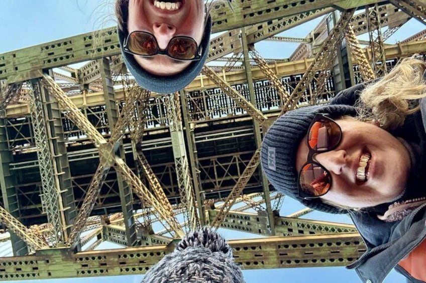 A person wearing a beanie and sunglasses, with a metal structure in the background. 3