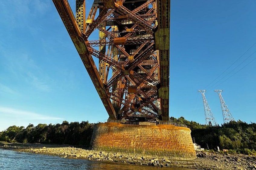 A large metal bridge structure with a clear blue sky in the background. 4
