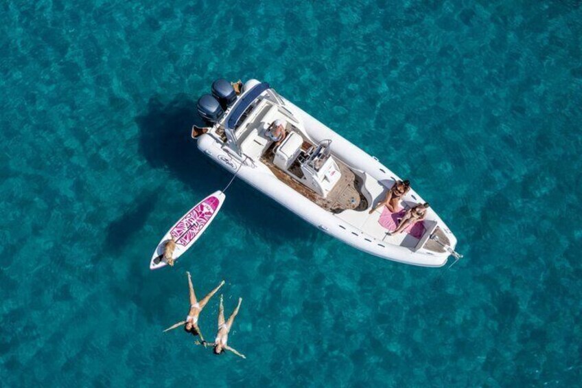 A boat with two people swimming in the water. 1