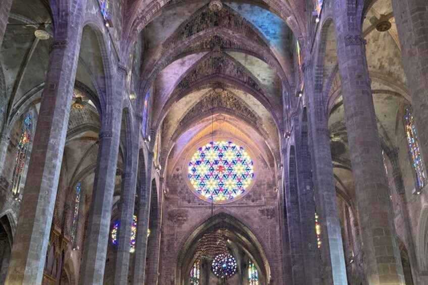 A cathedral interior with high vaulted ceilings, large stained glass windows, and Gothic arches. 4