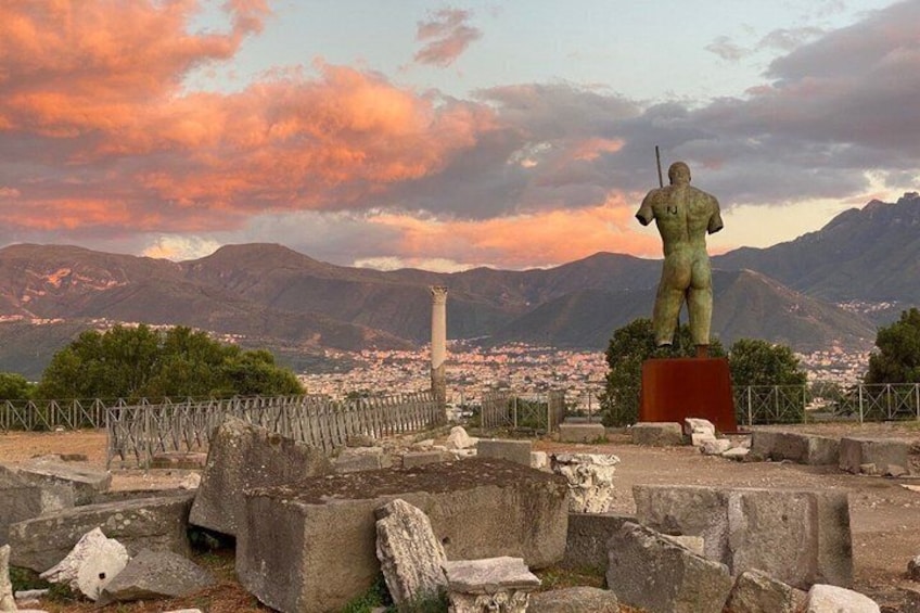 A statue on a pedestal with mountains in the background. 1