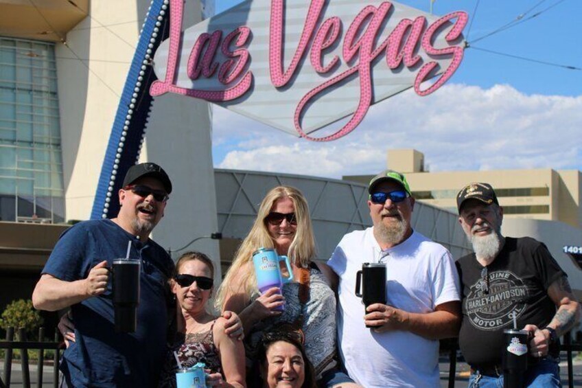 A group of people in front of the Las Vegas sign. 4