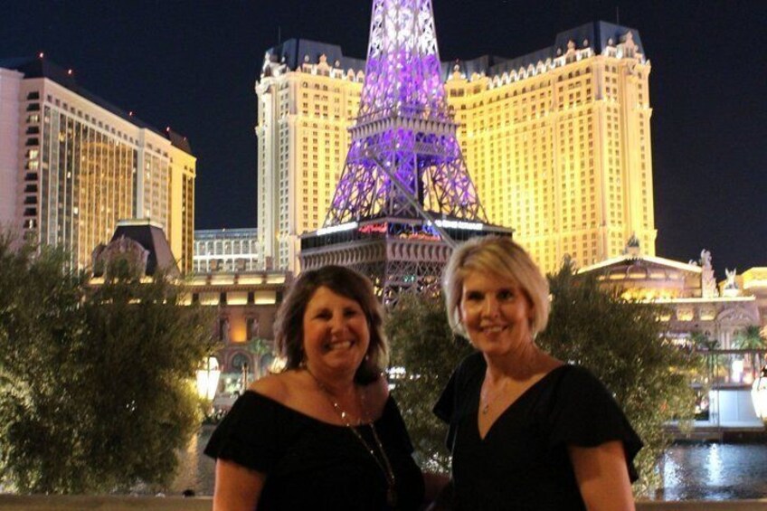 Two people standing in front of the Eiffel Tower with a casino in the background. 5