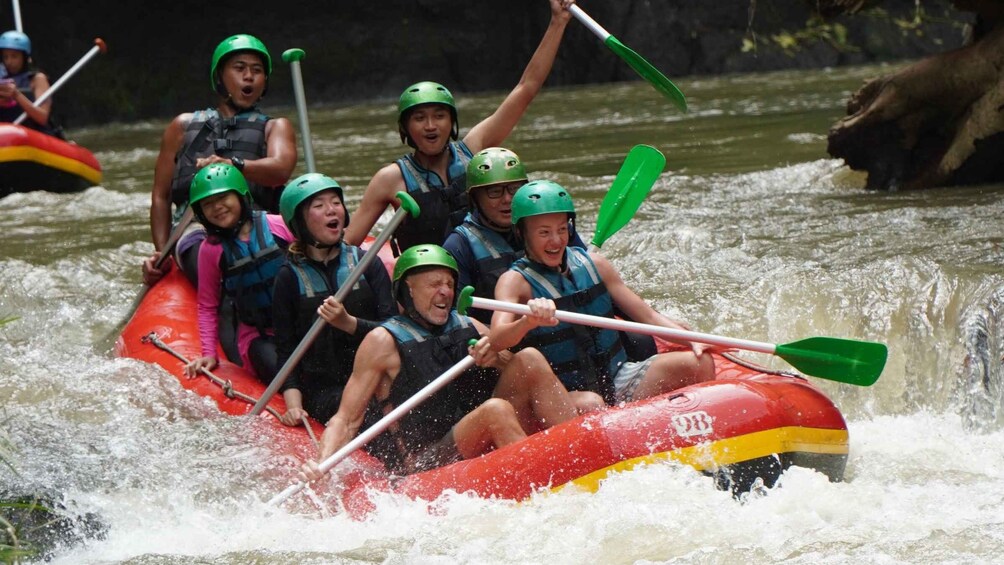 A group of people in a red raft navigating through a river with rapids. 1