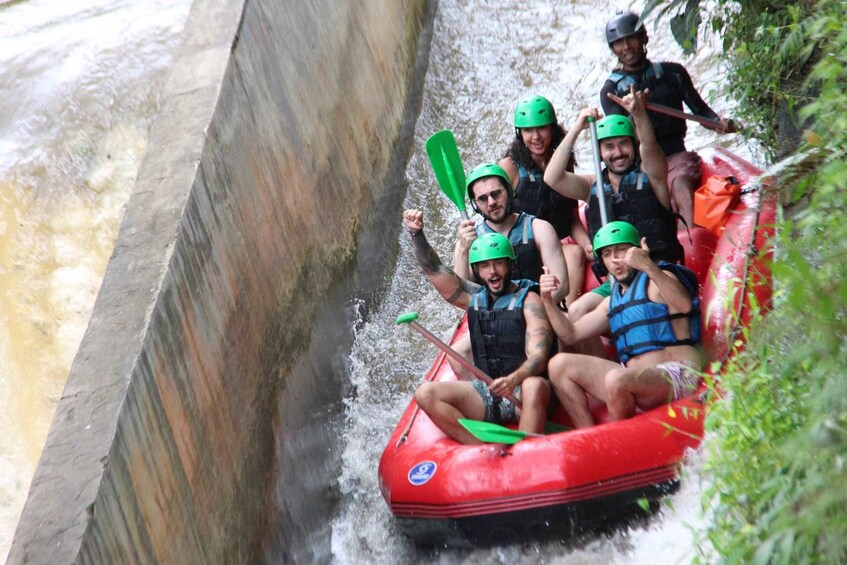 A group of people in a red raft navigating a narrow water channel. 5