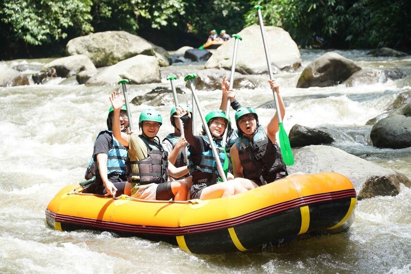 A group of people rafting on a river surrounded by rocks and trees. 3