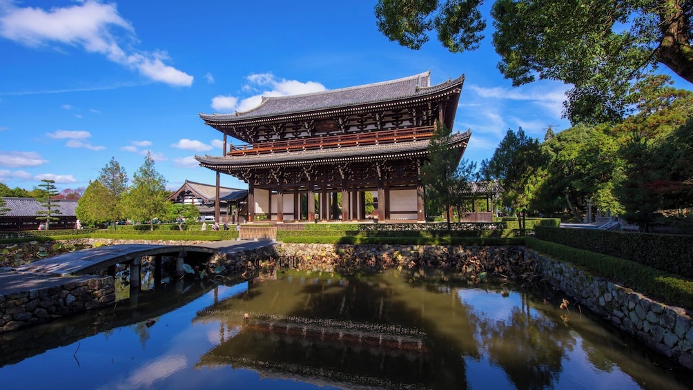 A traditional Japanese building with a reflection in a pond. 3