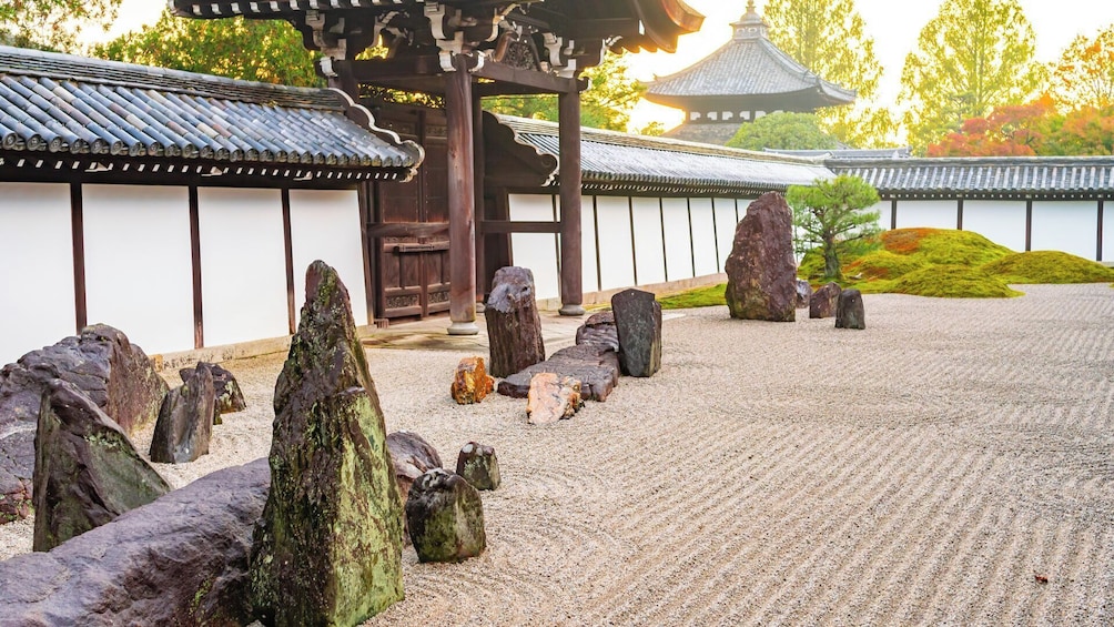 A traditional Japanese garden with a wooden torii gate, stone lanterns, and a pagoda in the background. 2
