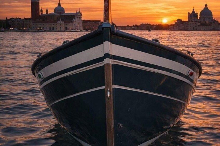 A boat with a striped pattern, a cityscape with domed buildings, and a sunset in the background. 3