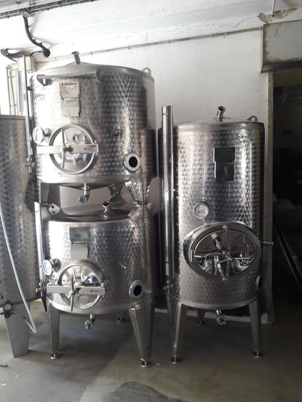 Two stainless steel fermentation tanks with gauges and valves, likely used for brewing or distilling. 3