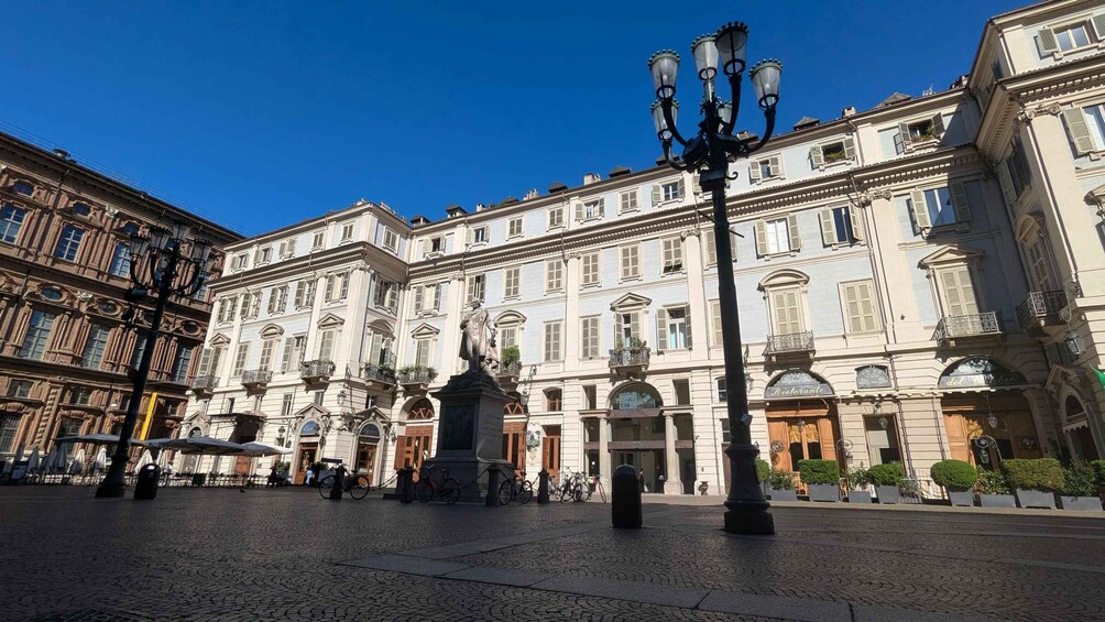 A historic square with ornate buildings, a statue, and a street lamp. 3