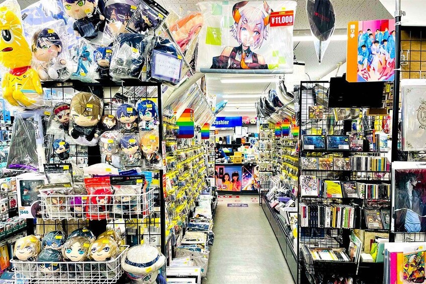 A store aisle with shelves stocked with anime merchandise, including plush toys and DVDs. 1