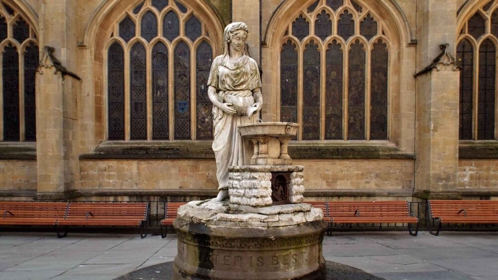A statue of a woman holding a child, standing on a stone pedestal with the inscription 'PATER IS BES.' 3