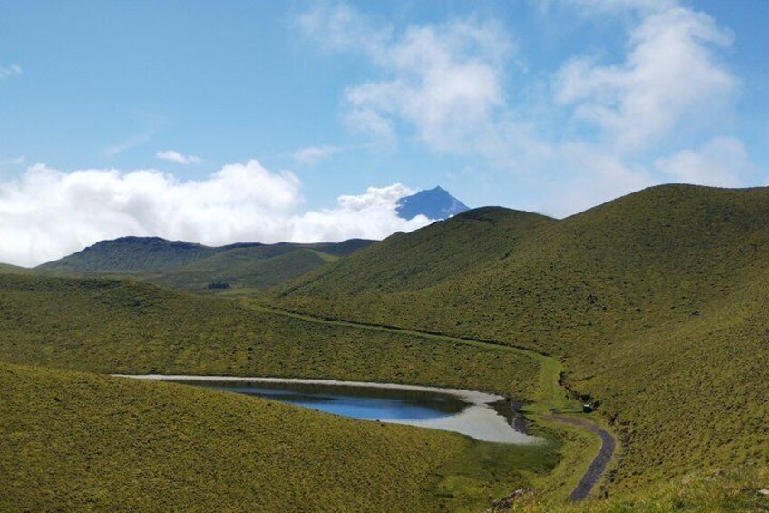 A mountainous landscape with a winding road and a lake. 4