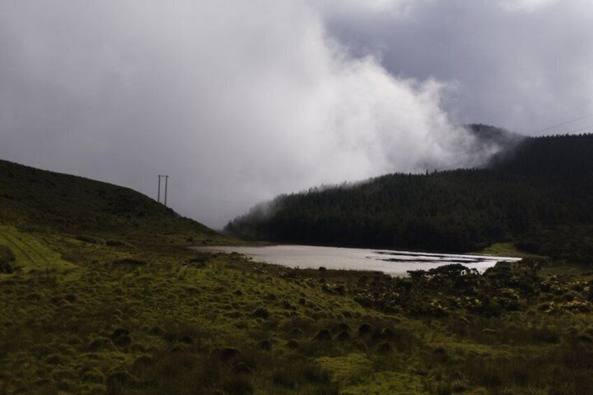 A lake surrounded by hills and a cloudy sky. 3