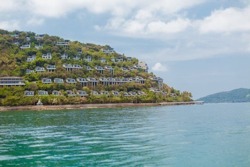 A coastal residential area with houses on a hillside overlooking the sea. 2