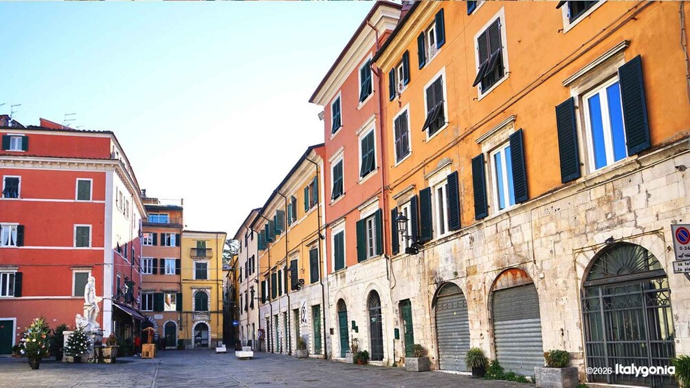 A street with colorful buildings, a statue, and a no parking sign. 2