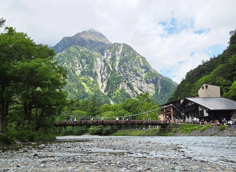 A wooden bridge over a river with a mountain in the background. 5